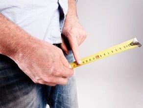 un uomo misura la lunghezza del pene prima dell'aumento con la soda